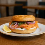 Smoked salmon bagel with capers, red onions, and dill on a rustic plate