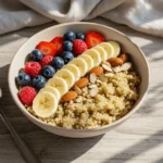 Quinoa breakfast bowl with fresh berries, bananas, and honey