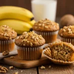 Freshly baked banana nut muffins with walnuts on a wooden table